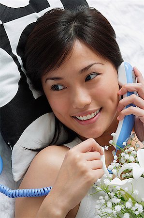 someone laying down aerial view - Young woman smiling while on the phone Stock Photo - Premium Royalty-Free, Code: 656-01766909