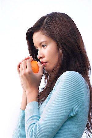 fruit smelling - Woman holding orange Stock Photo - Premium Royalty-Free, Code: 656-01766952