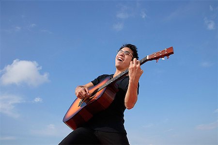 Man playing guitar outdoors Stock Photo - Premium Royalty-Free, Code: 656-01767115