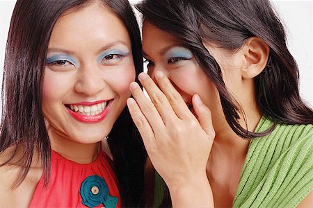 singapore women 30s - Two women, one smiling at camera, the other whispering to her Stock Photo - Premium Royalty-Free, Code: 656-01767285