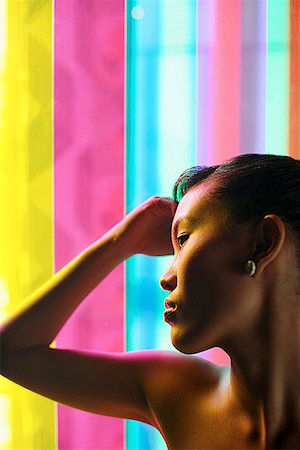 simsearch:656-01773560,k - Woman with hand on head, leaning against coloured glass Stock Photo - Premium Royalty-Free, Code: 656-01767321