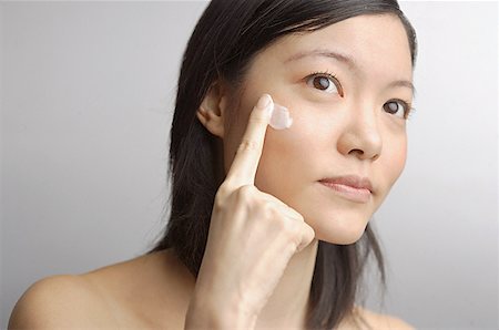 simsearch:614-03649478,k - Woman applying moisturizer to face Stock Photo - Premium Royalty-Free, Code: 656-01767470