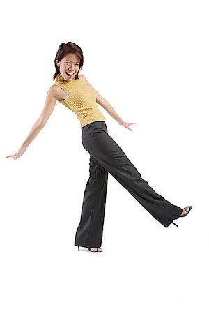 pants and high heels - Young woman kicking, looking at camera Stock Photo - Premium Royalty-Free, Code: 656-01767565