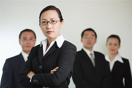 simsearch:656-01767698,k - Group of businesspeople, businesswoman in the foreground with arms crossed Foto de stock - Royalty Free Premium, Número: 656-01767649