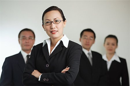 simsearch:656-01767698,k - Businesswoman with arms crossed, people in the background Foto de stock - Royalty Free Premium, Número: 656-01767650