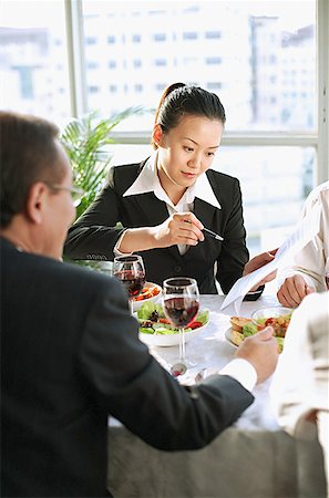 simsearch:656-01767698,k - Executives looking at documents over lunch Foto de stock - Royalty Free Premium, Número: 656-01767703