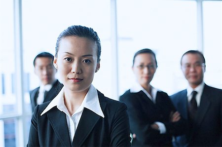 executive mentor - Businesswoman looking at camera, people in the background Stock Photo - Premium Royalty-Free, Code: 656-01767714