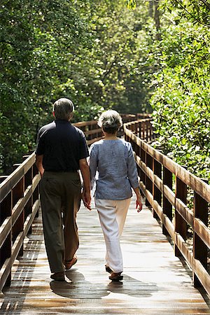 singapore tree bridge - Mature couple walking  on wooden bridge, rear view Stock Photo - Premium Royalty-Free, Code: 656-01767749