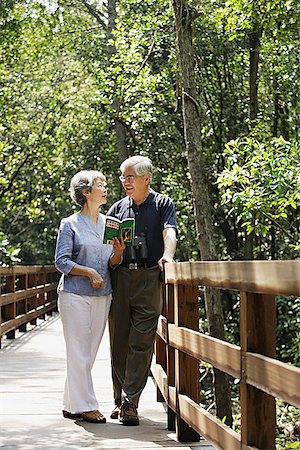 singapore tree bridge - Mature couple standing side by side, talking, woman holding book Stock Photo - Premium Royalty-Free, Code: 656-01767754