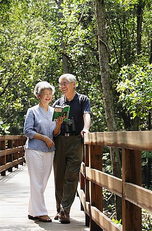 singapore tree bridge - Mature couple standing side by side, talking, woman looking at book Stock Photo - Premium Royalty-Free, Code: 656-01767755