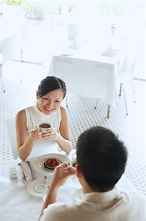 simsearch:656-01767905,k - Woman and man at cafe, woman holding cup of coffee, high angle view Fotografie stock - Premium Royalty-Free, Codice: 656-01767804