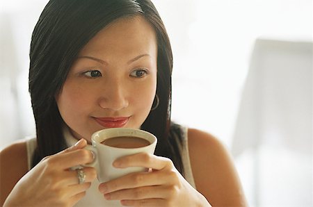 singapore women 30s - Young woman, holding cup of coffee, looking away Stock Photo - Premium Royalty-Free, Code: 656-01767801