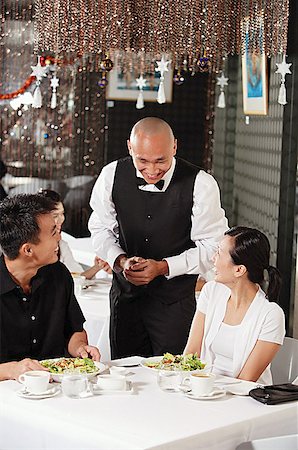 simsearch:656-01767905,k - Waiter talking to couple at restaurant Fotografie stock - Premium Royalty-Free, Codice: 656-01767844