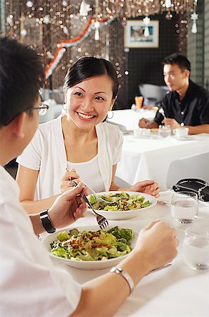 Couple eating at restaurant, people in the background Fotografie stock - Premium Royalty-Free, Codice: 656-01767848