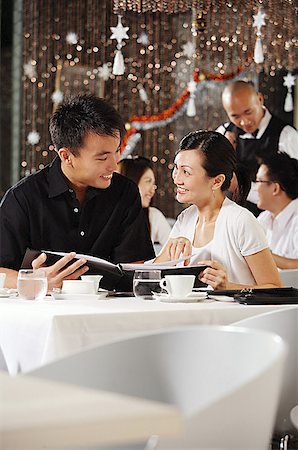 simsearch:656-01767905,k - Couple in restaurant, holding menu, smiling at each other Fotografie stock - Premium Royalty-Free, Codice: 656-01767841