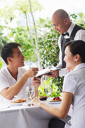 simsearch:656-01767905,k - Couple in restaurant, making payment to waiter Fotografie stock - Premium Royalty-Free, Codice: 656-01767864