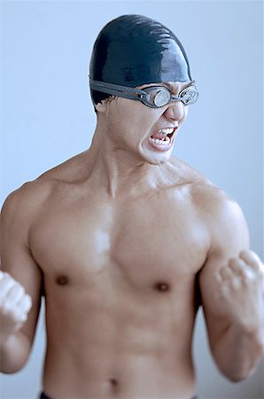 simsearch:656-01767934,k - Man wearing swimming cap and goggles, making fists and grimacing Foto de stock - Sin royalties Premium, Código: 656-01767962