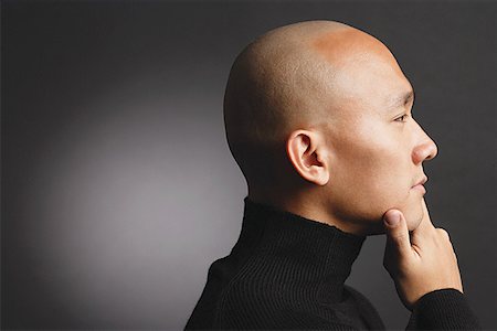 Man with shaved head, hand on chin, profile Stock Photo - Premium Royalty-Free, Code: 656-01768030