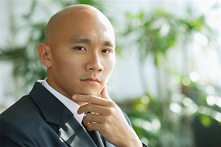 singapore business men - Businessman, hand on chin, looking at camera Stock Photo - Premium Royalty-Free, Code: 656-01768076