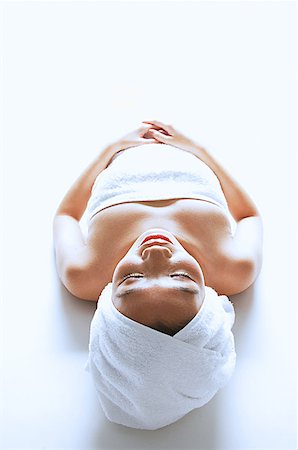 Woman wrapped in a towel, lying down, eyes closed Stock Photo - Premium Royalty-Free, Code: 656-01768111