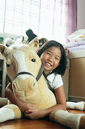 portrait photography with girls and horses - Girl in bedroom, hugging stuffed toy Stock Photo - Premium Royalty-Free, Code: 656-01768155