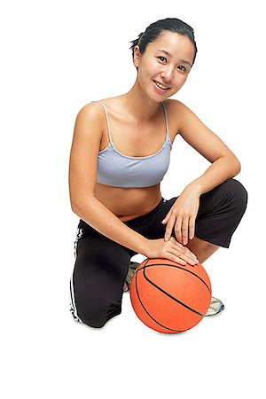 Woman crouching on floor, hand on basketball Stock Photo - Premium Royalty-Free, Code: 656-01768202