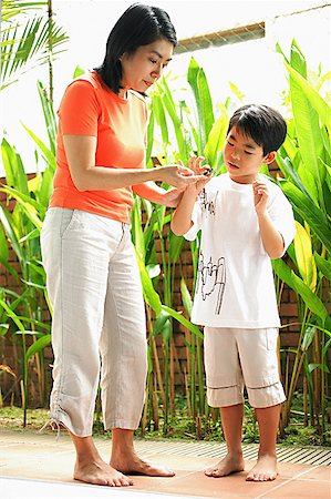 Mother and son standing, looking at terrapin Stock Photo - Premium Royalty-Free, Code: 656-01768220