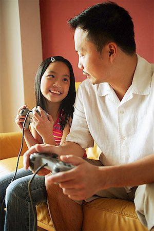simsearch:655-01781357,k - Father and daughter looking at each other, holding video game controllers Stock Photo - Premium Royalty-Free, Code: 656-01768259
