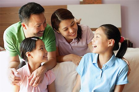 father at bed being hug - Father and mother with two daughters in bedroom Stock Photo - Premium Royalty-Free, Code: 656-01768298