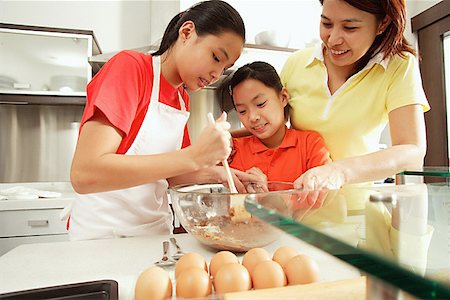 simsearch:656-01768260,k - Mother and two daughters in kitchen Fotografie stock - Premium Royalty-Free, Codice: 656-01768303