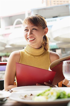 Woman in cafe, holding menu, looking away Stock Photo - Premium Royalty-Free, Code: 656-01768442