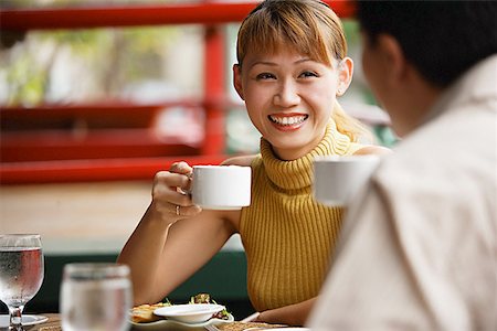 simsearch:656-01767905,k - Couple in cafe, holding cups, woman smiling Fotografie stock - Premium Royalty-Free, Codice: 656-01768456