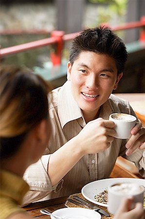 simsearch:656-01767905,k - Couple in cafe, man holding cup, looking at woman Fotografie stock - Premium Royalty-Free, Codice: 656-01768457