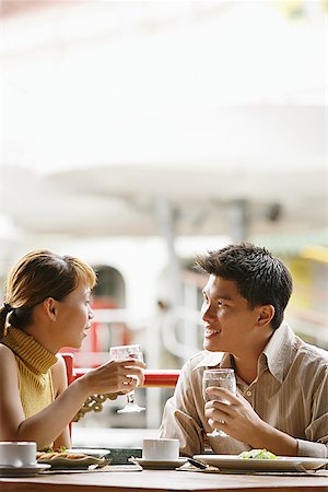 simsearch:656-01767905,k - Couple in cafe, sitting side by side, holding glasses of water Fotografie stock - Premium Royalty-Free, Codice: 656-01768459