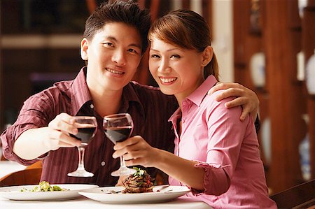 simsearch:400-04454151,k - Couple in restaurant, looking at camera, toasting with wine glasses Stock Photo - Premium Royalty-Free, Code: 656-01768495