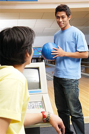 simsearch:656-01768686,k - Homme debout en bowling allié, boule de bowling de détention, un autre homme assis en face de lui Photographie de stock - Premium Libres de Droits, Code: 656-01768659