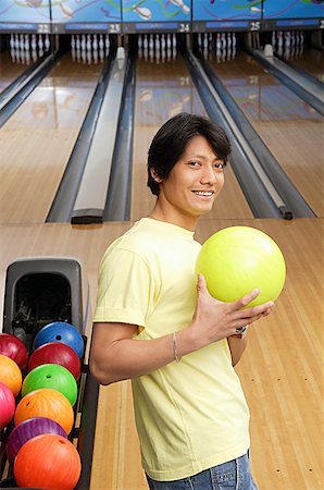 Man with bowling ball, looking at camera Stock Photo - Premium Royalty-Free, Code: 656-01768662