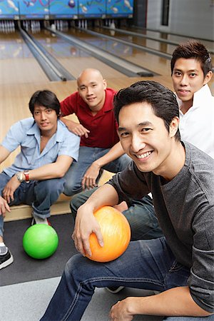 Four men in bowling alley, smiling at camera Stock Photo - Premium Royalty-Free, Code: 656-01768670