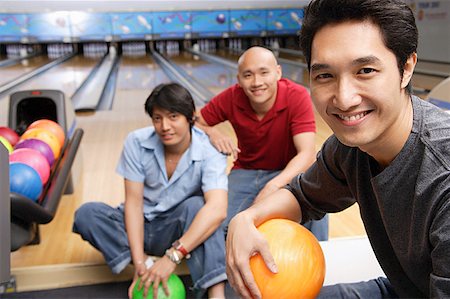 simsearch:656-01772853,k - Three men in bowling alley, smiling at camera Fotografie stock - Premium Royalty-Free, Codice: 656-01768671