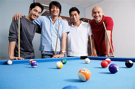 pool cue - Men standing around pool table, looking at camera Foto de stock - Sin royalties Premium, Código: 656-01768686