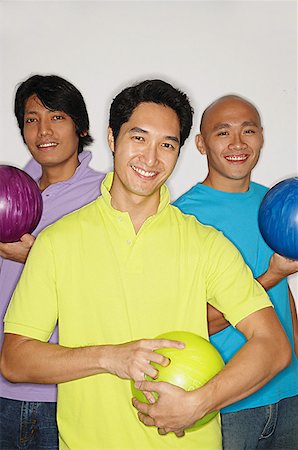 simsearch:656-01772853,k - Three men holding bowling balls, smiling at camera Fotografie stock - Premium Royalty-Free, Codice: 656-01768713
