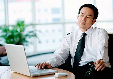 simsearch:694-03330980,k - Businessman in office using laptop Stock Photo - Premium Royalty-Free, Code: 656-01768775