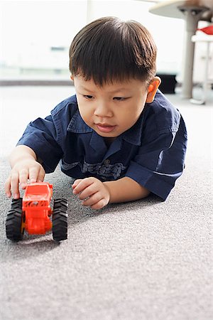simsearch:656-01766387,k - Jeune garçon couché sur le sol, jouant avec tracteur jouet Photographie de stock - Premium Libres de Droits, Code: 656-01768820