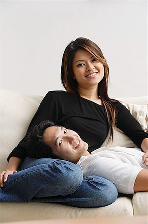 Couple on sofa, man lying on womans lap, both smiling at camera Stock Photo - Premium Royalty-Free, Code: 656-01769019