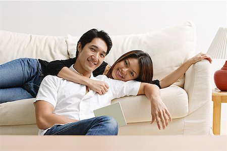 simsearch:656-01768177,k - Couple in living room, woman lying on sofa, man sitting on floor in front of her Stock Photo - Premium Royalty-Free, Code: 656-01769011