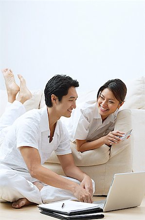 friends talking sofa and two people - Couple at home, looking at laptop woman holding calculator Foto de stock - Sin royalties Premium, Código: 656-01769031