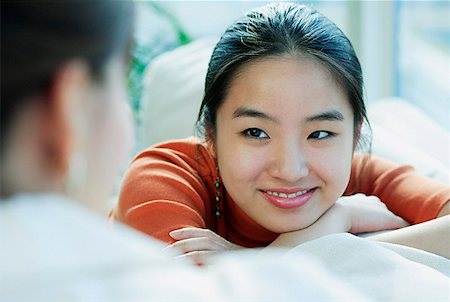 simsearch:693-03305464,k - Young woman smiling at person in front of her Stock Photo - Premium Royalty-Free, Code: 656-01769070