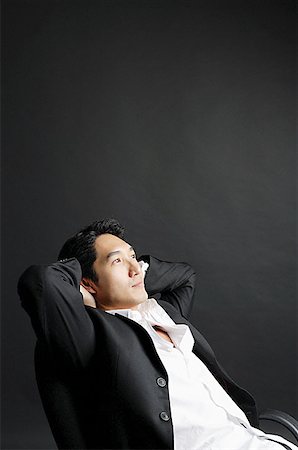 Man sitting, leaning back, hands on head Stock Photo - Premium Royalty-Free, Code: 656-01769123