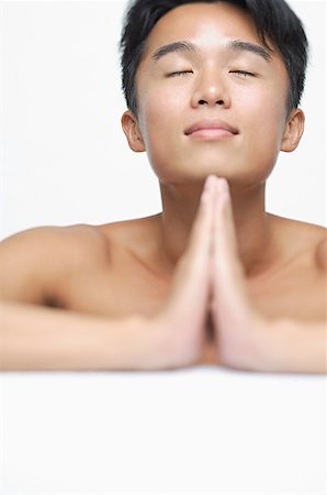 eyes closed portrait of asian man - Man with eyes closed and hands together Stock Photo - Premium Royalty-Free, Code: 656-01769168