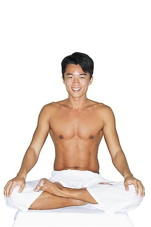 Man sitting in yoga position, smiling at camera Stock Photo - Premium Royalty-Free, Code: 656-01769176